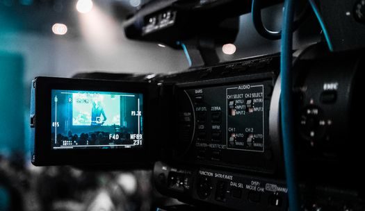 HD video camera capturing a live event; focus on screen and controls.